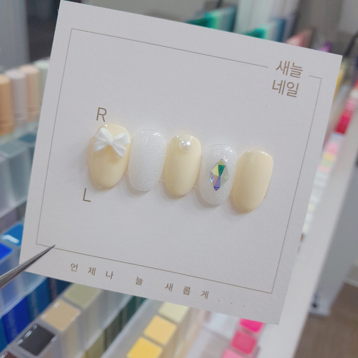 파스텔 옐로우 컬러에 리본 파츠를 넣어서 귀여운 느낌에 네일입니다!